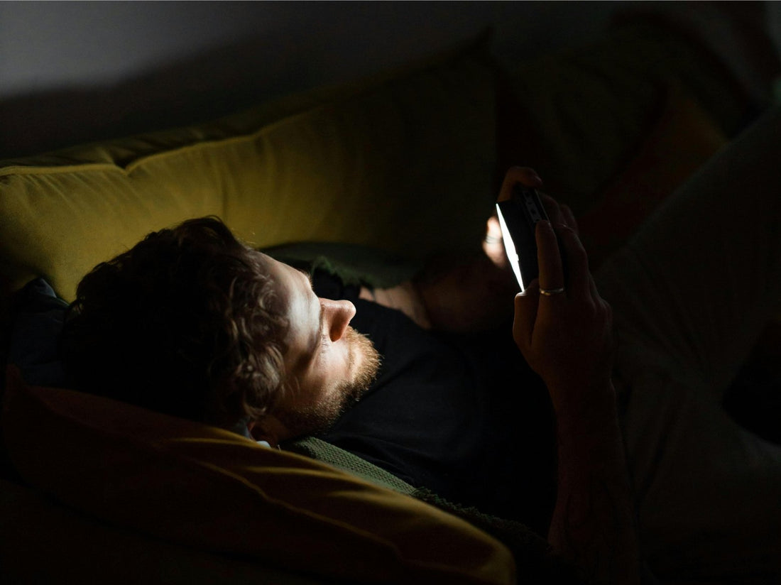 digital eyestrain: a man is playing his cellphone in a dark environment for a long time